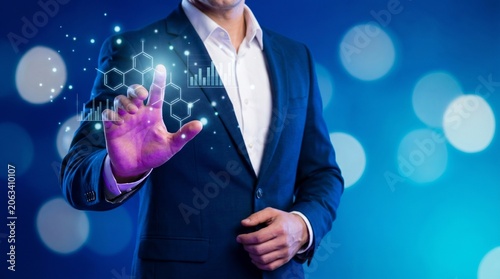 Business professional holding digital globe with futuristic technology interface in modern office