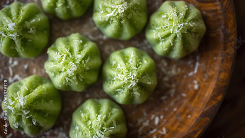Green Coconut Mochi Sweets with Shredded Coconut Topping on Wooden Plate