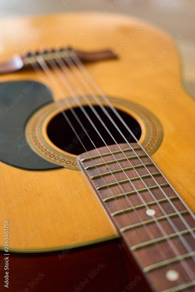 Fototapeta premium Close up of acoustic folk guitar strings and soundhole with wooden body