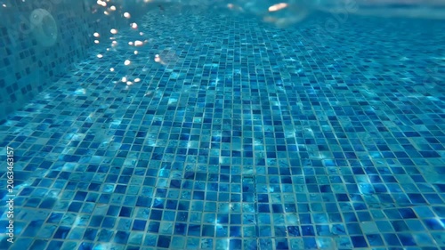 Tranquil atmosphere of clear blue swimming pool water reflecting sunlight vibrant tiles, showcasing shimmering floor and inviting light reflections