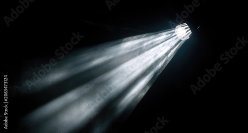 Spotlight beams radiating from a light source in a dark space