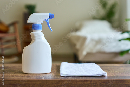 Spray bottle and microfiber cloth on wooden table for house cleaning