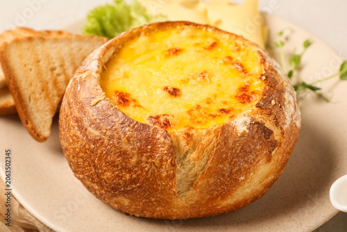 Cheese soup in bread bowl o...