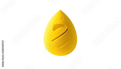 A vibrant yellow, teardrop-shaped cosmetic applicator isolated on a black background, with carved swirls enhancing its form