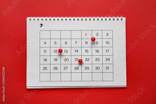 Obraz na płótnie Calendar with pins on red background