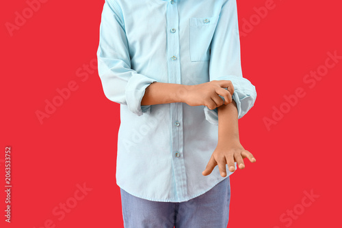 Bild auf Leinwand Little boy rolling up his sleeve on red background