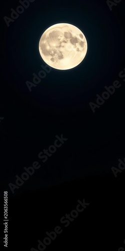 Giant moon hangs in dark night sky, casting an ethereal glow over a silhouetted landscape,  universe,  space