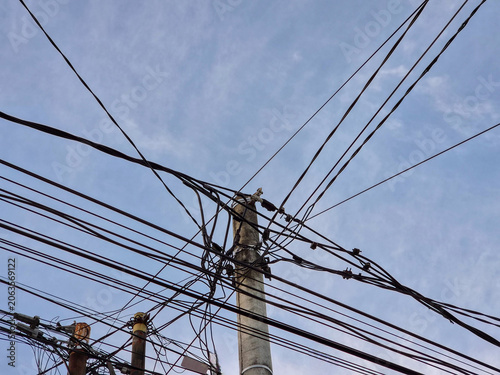 Messy electrical cables and power lines on a utility pole