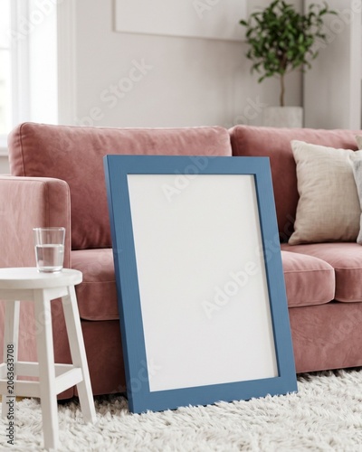 Blank blue frame mockup leaning against dusty pink velvet sofa in cozy living room