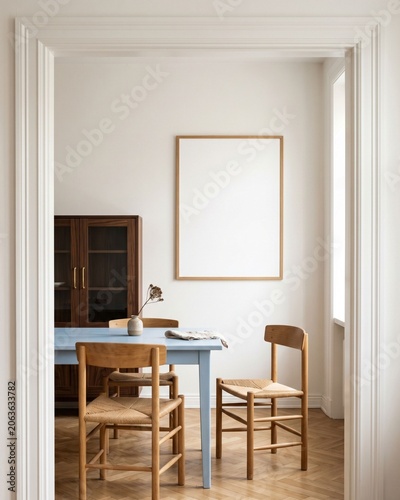 Blank wood frame mockup in charming dining nook with pastel blue table viewed through doorway