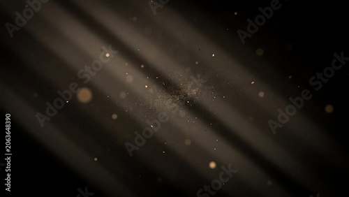 Golden particles and light rays on a dark background with bokeh effect