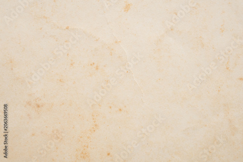 Old vintage paper texture background with aged stains and antique yellowed parchment effect