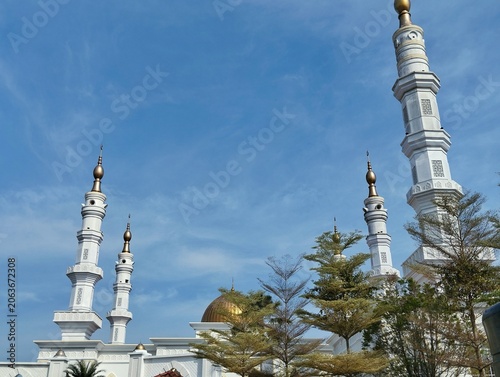 Mosque tower with a serene blue sky background.