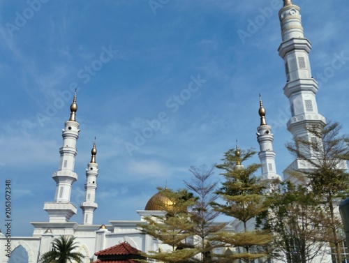 Mosque tower with a serene blue sky background.