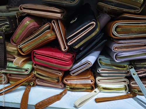 Fotografie Close up view of a colorful pile of various women's leather wallets with metal zippers on display at a retail store