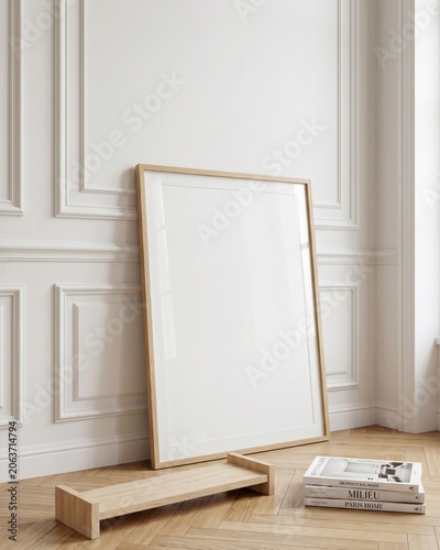Blank wood frame mockup leaning on wood floor against classic white paneled wall