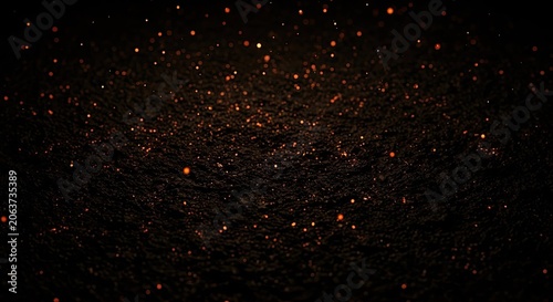 Orange sparks and glowing embers on dark textured ground