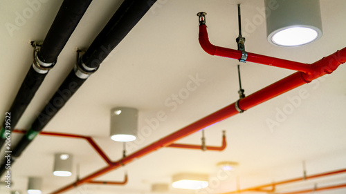 Konstfotografi Automatic fire sprinkler safety system with red suppression pipes and sprinkler