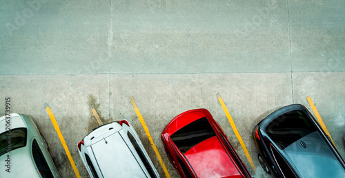 Obraz na płótnie Top view of car parked at concrete car parking lot with yellow line of traffic sign on the street