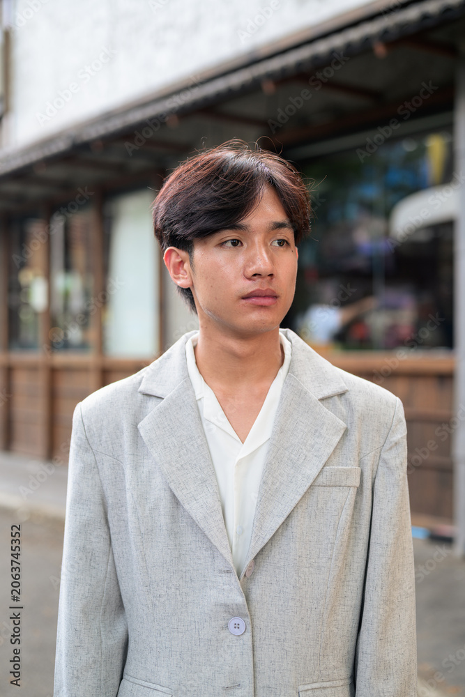 Obraz premium Portrait of non-binary Thai Isan professional looking away outdoors