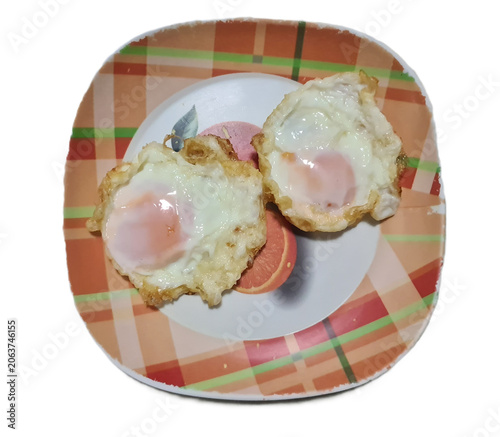 two Thai deep fried eggs in orange plate isolated on white background