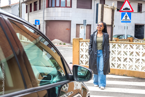 Foto Confident smiling black woman crossing road in city