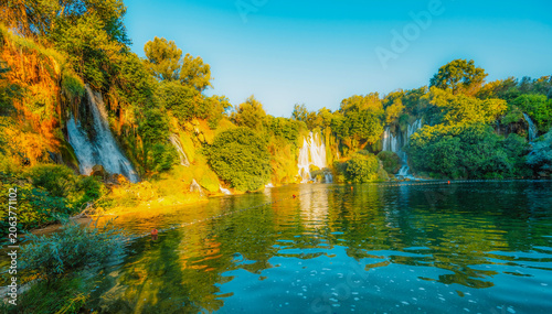 Foto Kravice Waterfalls on the Trebižat River, a natural amphitheater of cascading water and lush green nature near Ljubuški, Bosnia and Herzegovina