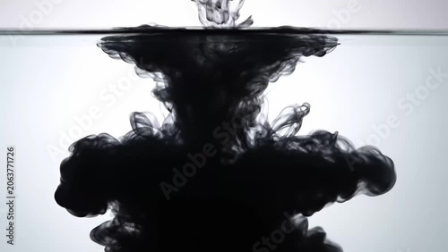 Black ink cloud blooming in water, abstract explosion of dark liquid, dynamic fluid art, and mesmerizing underwater spectacle