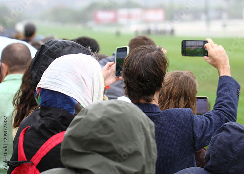 Tableau sur toile Fotografiar con móvil y grabar con teléfono público espectador hipódromo y cabal