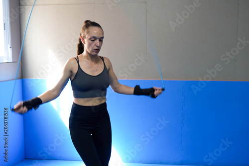 Female jump rope. Serene workout scene of woman practicing jump rope with tranquil sunlight