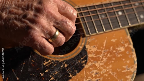 An Artisan's Touch: Capturing the Elegance and Craftsmanship of Traditional Guitar Playing with a Close-Up of a Hand Strumming Harmoniously