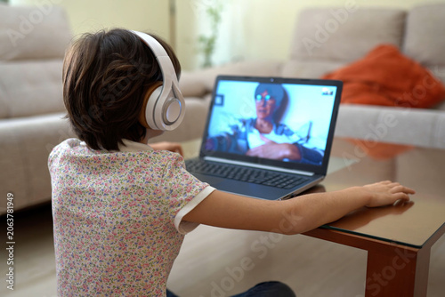 Young patient with headphones participating in remote medical consultation with support