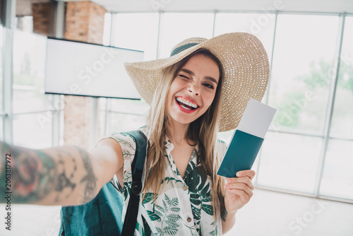 Bild auf Leinwand Young woman at an airport terminal holding a travel ticket, smiling brightly, an