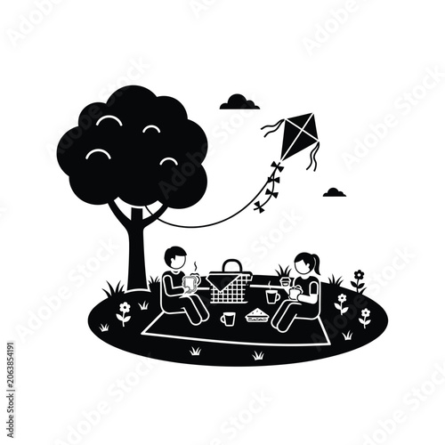 Family enjoying a picnic under a tree with a kite flying.