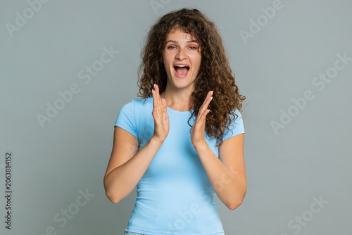 Canvas Print Young woman joyfully laughing clapping hands excitedly expressing genuine happiness and cheerful emotional reaction