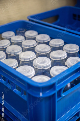 Reusable Milk Bottles Stored in Blue Plastic Crate