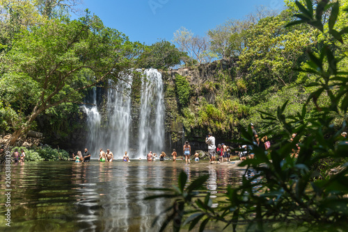 Tourists swimming at tropical waterfall in Costa Rica jungle