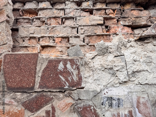 Vászonkép Old Damaged Brick Wall with Crumbling Mortar Mixed Stone Tiles Weathered Buildin