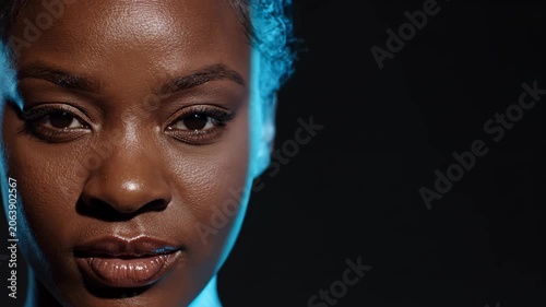 African american woman close up with shifting blue light beam across face. Cyber security facial recognition scan and biometric identification data concept