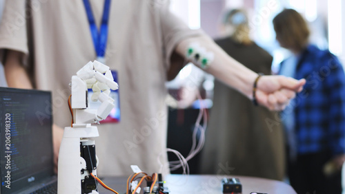 Obraz na plátně Person testing a bionic robotic hand controlled by muscle sensors connected to t