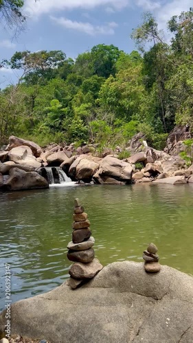 Mountain Lake with Small Waterfall in Vietnam - Balanced Stone Pyramids and Rock Stacks by Water - Peaceful Highland Lake Landscape with Zen Stones