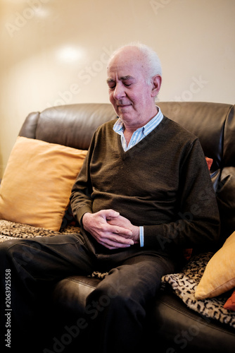 Fotografi Senior man experiencing stomach pain and indigestion at home