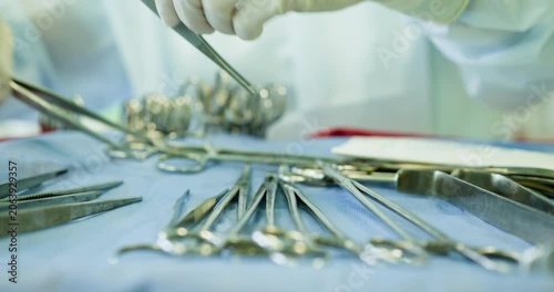 Healthcare professional organizing surgical instruments on sterile table for cleanliness and readiness. Healthcare Professionals Responsible for Handling and Managing Surgical Instruments Effectively