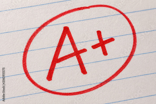 Red A plus grade circled on lined notebook paper symbolizing academic success and excellent school performance
