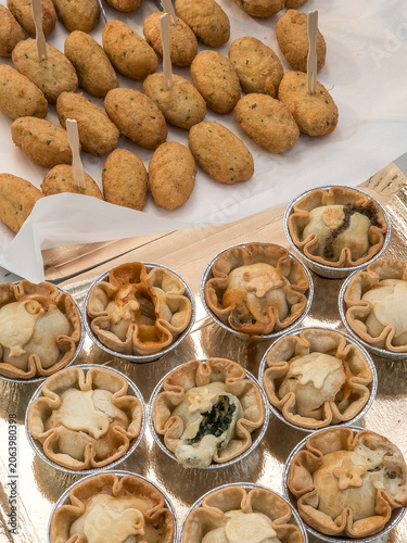 Assorted Portuguese appetizers, pies, and cod fritters on a festive table, ready to eat, with many pieces in close up for a real family meal.