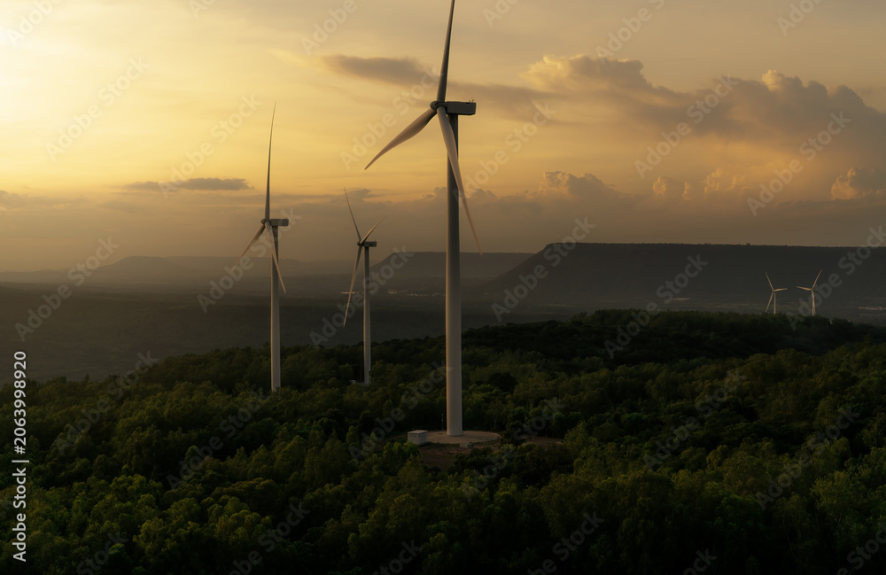 Obraz premium Wind energy. Wind power. Sustainable, renewable energy. Wind turbines generate electricity. Windmill farm on a mountain with sunset sky. Green technology. Renewable resource. Sustainable development.