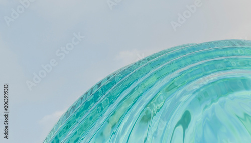 Abstract view of light blue spiraling glass with a soft sky backdrop.