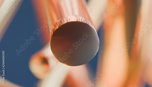 Closeup of a shiny copper pipe with abstract blurred background