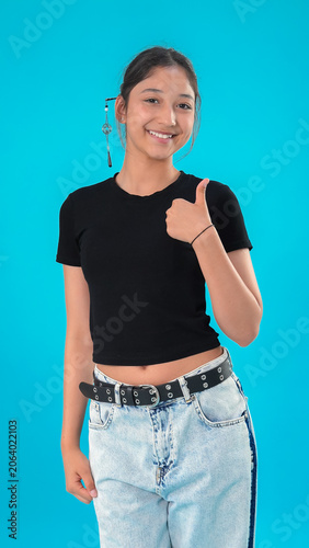 A young woman gives a thumbs up gesture of approval