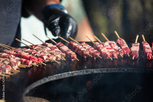 Raw arrosticini meat skewers grilling on barbecue